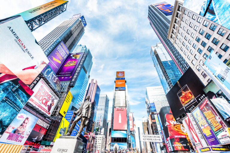 Blick nach oben auf den Times Square in New York mit zahlreichen großformatigen digitalen Werbetafeln und LED-Bildschirmen an den Hochhäusern. Die Aufnahme verdeutlicht die hohe Sichtbarkeit digitaler Außenwerbung und eignet sich zur Veranschaulichung des Vergleichs zwischen digitalen und analogen Werbetafeln.