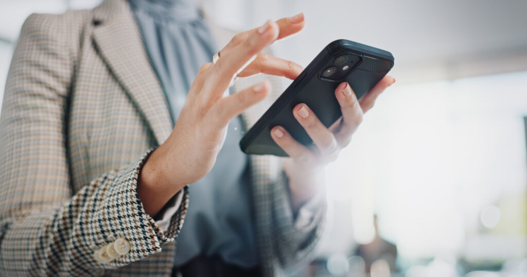 Nahaufnahme einer Person, die ein Smartphone in der Hand hält und den Bildschirm bedient. Das Bild symbolisiert die Nutzung sozialer Medien im beruflichen Kontext und eignet sich zur Veranschaulichung des Themas „Seriös oder Lachnummer: Social Media für Unternehmen“.
